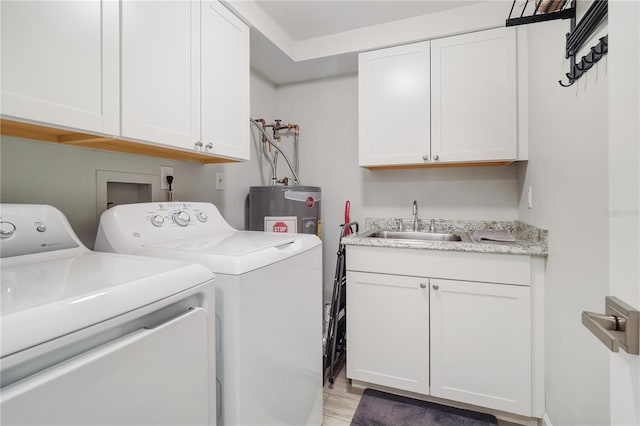 washroom featuring a sink, cabinet space, water heater, and washer and clothes dryer