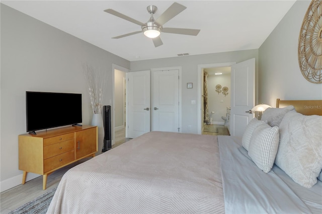 bedroom with visible vents, connected bathroom, ceiling fan, baseboards, and light wood-style floors