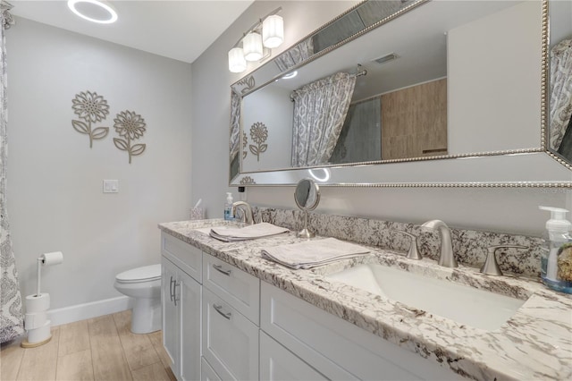 full bath featuring a tile shower, visible vents, toilet, and a sink