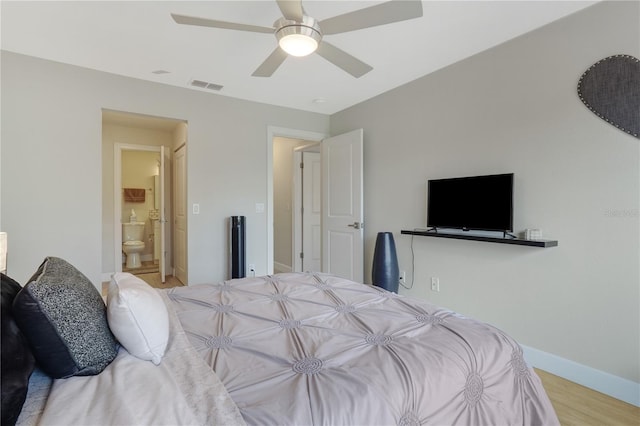 bedroom featuring wood finished floors, baseboards, visible vents, ceiling fan, and connected bathroom