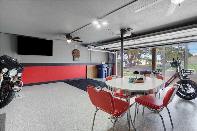 dining room with ceiling fan, concrete block wall, speckled floor, and a textured ceiling