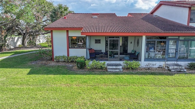 back of property featuring a yard, covered porch, and a tile roof