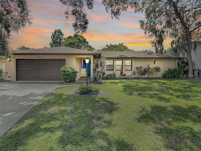 ranch-style home with a yard and a garage