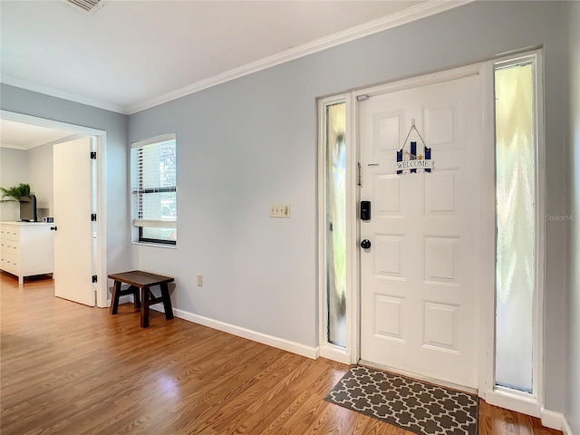 foyer featuring hardwood / wood-style floors and crown molding