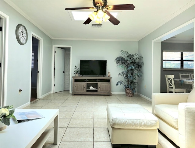 living room featuring a skylight, ceiling fan, ornamental molding, and light tile patterned flooring