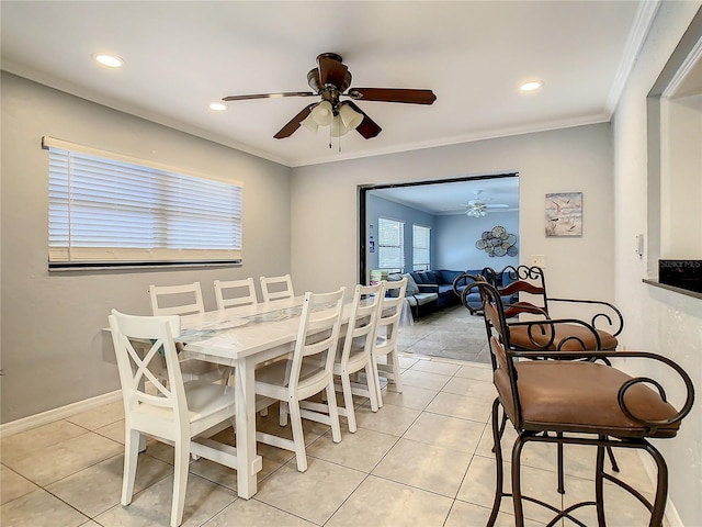 tiled dining area featuring ornamental molding and ceiling fan