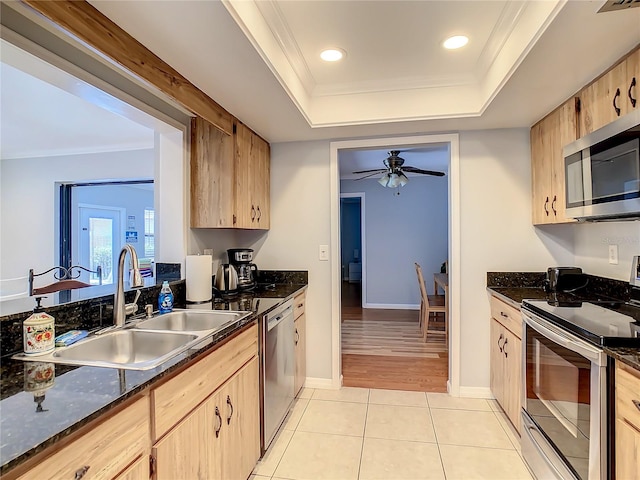 kitchen featuring appliances with stainless steel finishes, light tile patterned floors, light brown cabinetry, and sink