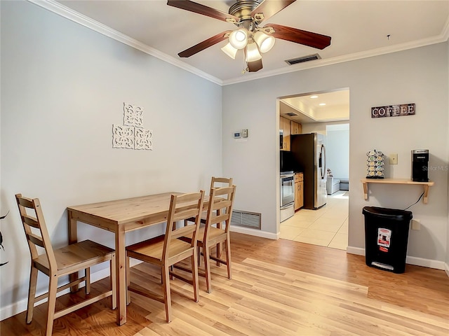 dining room featuring ceiling fan, light hardwood / wood-style flooring, and crown molding