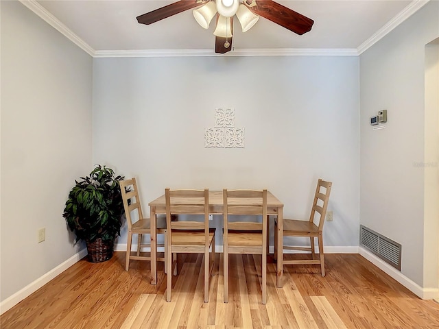 dining space featuring ornamental molding, ceiling fan, and light wood-type flooring