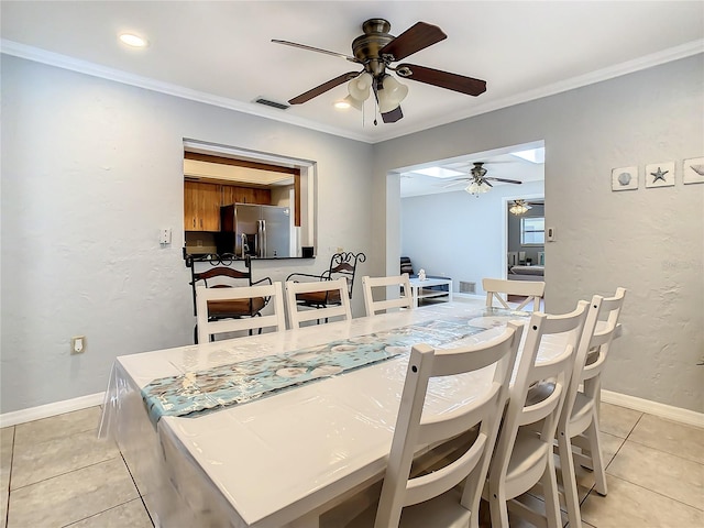 dining area featuring ceiling fan, crown molding, and light tile patterned floors