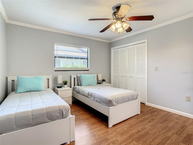 bedroom with ceiling fan, a closet, ornamental molding, and hardwood / wood-style flooring