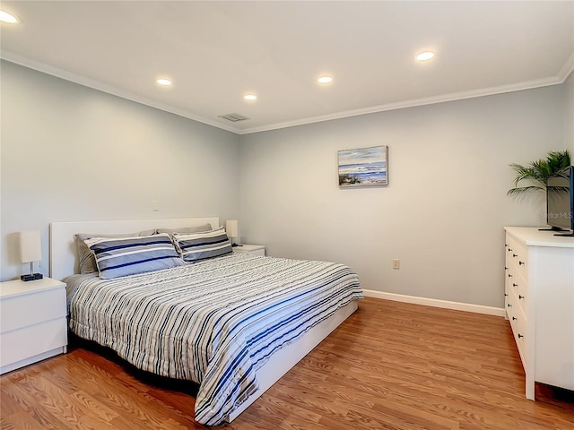 bedroom featuring ornamental molding and hardwood / wood-style flooring