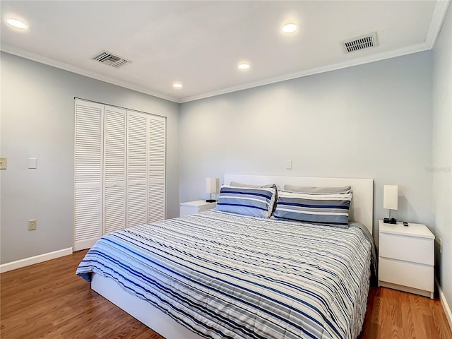 bedroom featuring a closet, ornamental molding, and dark hardwood / wood-style floors