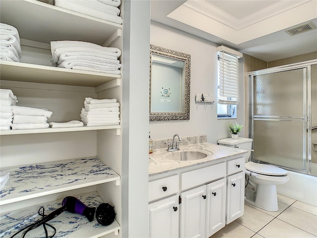 full bathroom featuring combined bath / shower with glass door, vanity, crown molding, tile patterned flooring, and toilet