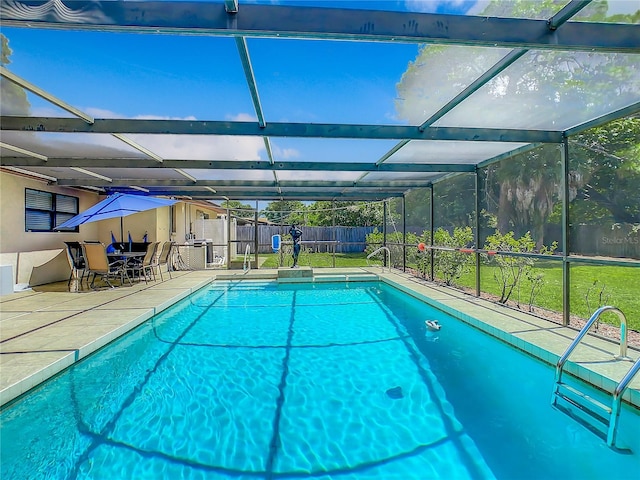 view of swimming pool featuring a lanai, a lawn, and a patio