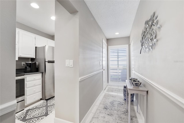 interior space with light tile patterned floors and a textured ceiling