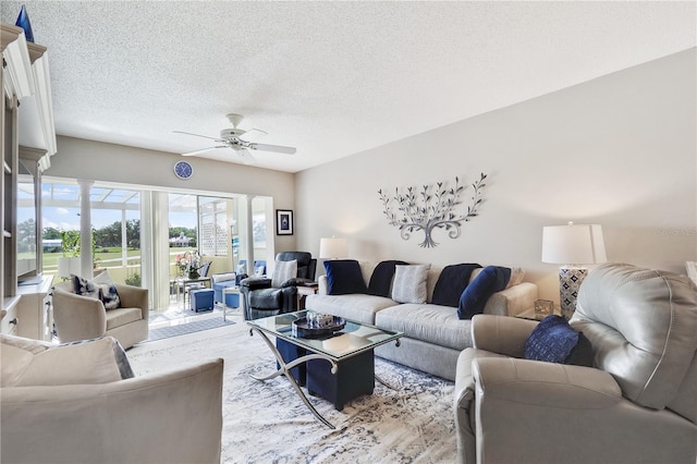 living room with ceiling fan and a textured ceiling