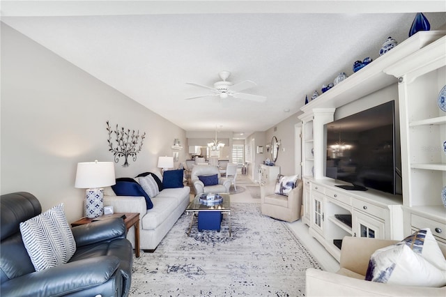 living room with a textured ceiling and ceiling fan with notable chandelier