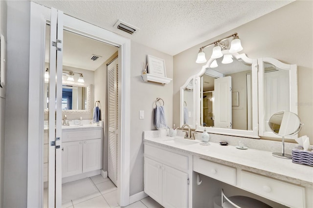 bathroom featuring tile patterned floors, vanity, and a textured ceiling