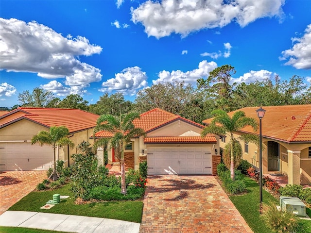 mediterranean / spanish home featuring a front yard and a garage