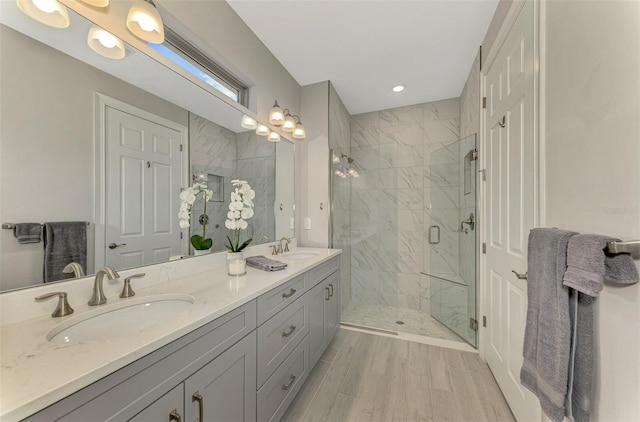 bathroom with a shower with door, vanity, and wood-type flooring