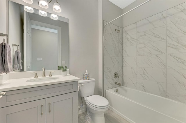 full bathroom with tiled shower / bath combo, toilet, and vanity