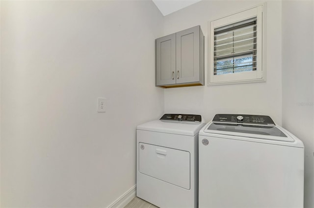 washroom featuring cabinets, light wood-type flooring, and independent washer and dryer