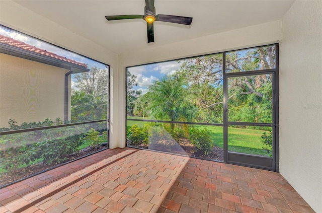 unfurnished sunroom featuring a wealth of natural light and ceiling fan