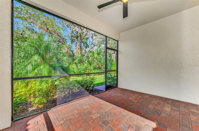 unfurnished sunroom featuring ceiling fan