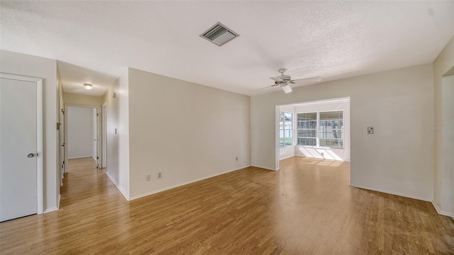 spare room featuring ceiling fan, a textured ceiling, and light wood-type flooring