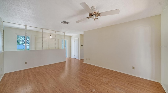 empty room featuring ceiling fan, a textured ceiling, and light wood-type flooring