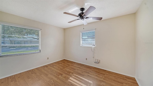 spare room with ceiling fan, light hardwood / wood-style flooring, and a textured ceiling