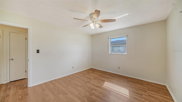 spare room with ceiling fan, light hardwood / wood-style floors, and a textured ceiling