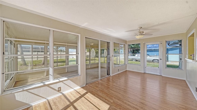 unfurnished sunroom featuring ceiling fan