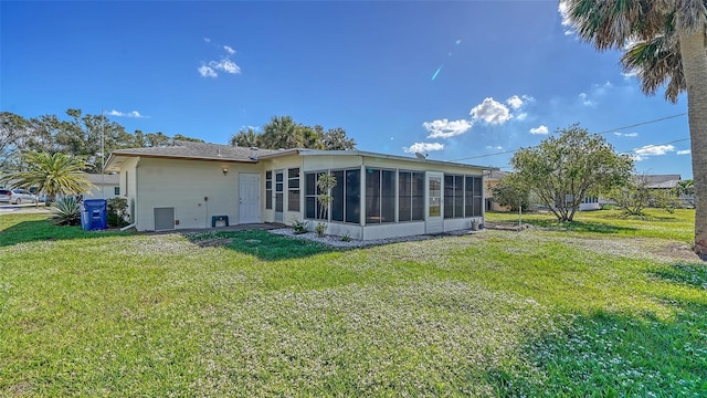 back of property with a lawn and a sunroom