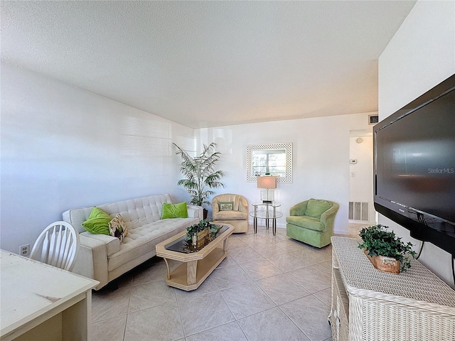 living room featuring light tile patterned flooring and a textured ceiling