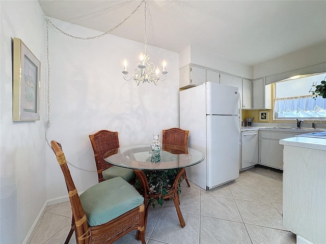 kitchen with pendant lighting, white appliances, white cabinets, sink, and a chandelier