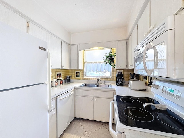 kitchen with sink, white cabinets, white appliances, and light tile patterned floors