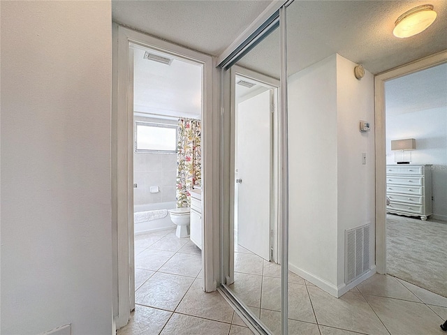 hall featuring light tile patterned floors