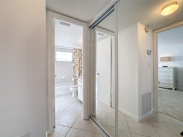 210 Park Blvd N Unit 129, Venice, FL 34285 - hall featuring light tile patterned floors and a textured ceiling