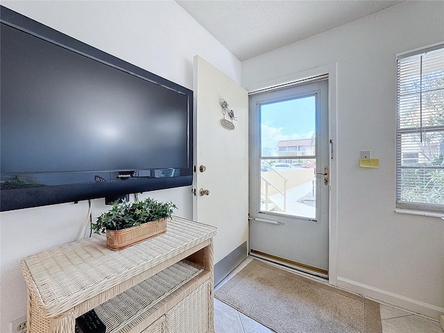 210 Park Blvd N Unit 129, Venice, FL 34285 - doorway to outside with plenty of natural light, light tile patterned flooring, and baseboards