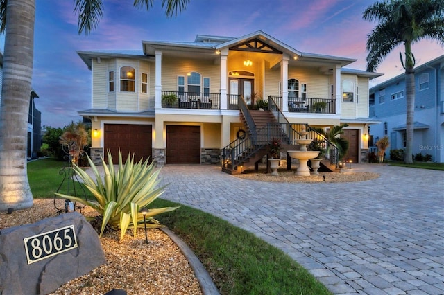 view of front of property featuring french doors, covered porch, and a garage