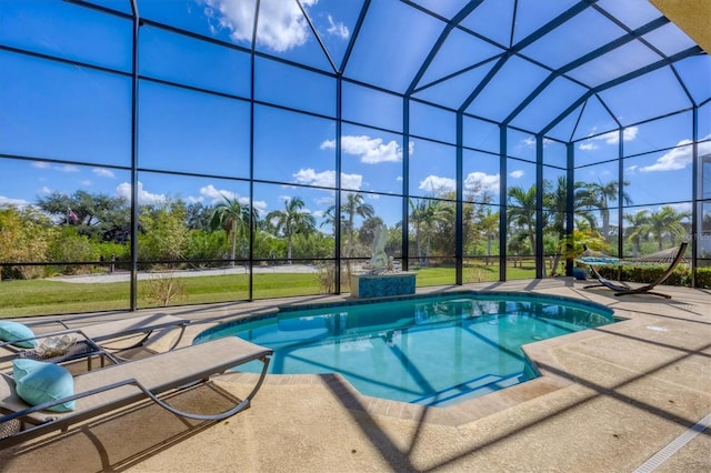 view of swimming pool featuring glass enclosure and a patio