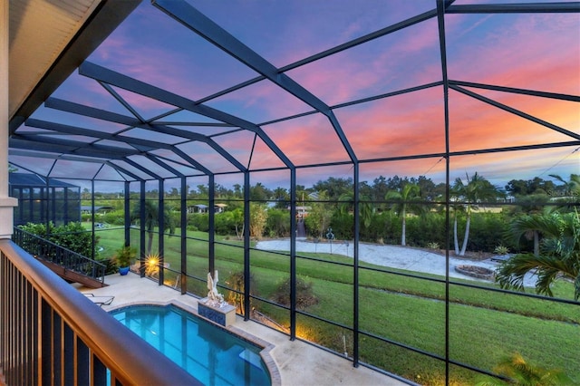 pool at dusk featuring a yard and a lanai