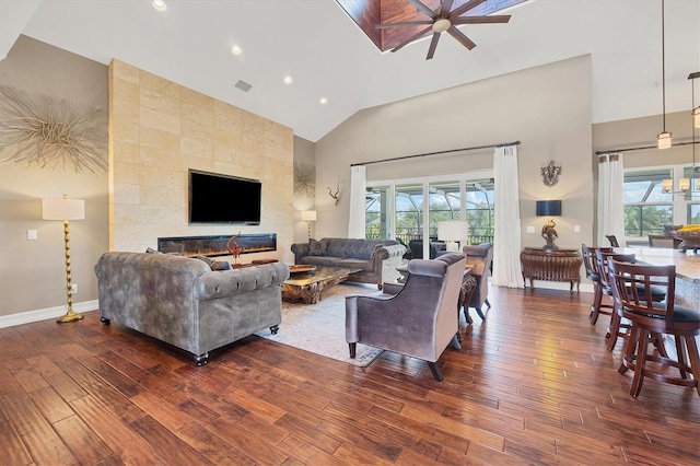 living room featuring a wealth of natural light, ceiling fan, and dark wood-type flooring