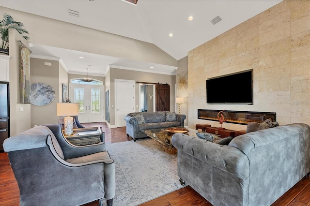 living room with french doors, vaulted ceiling, dark hardwood / wood-style floors, ornamental molding, and a fireplace