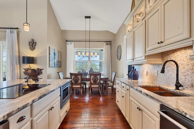 kitchen with black electric stovetop, sink, pendant lighting, a notable chandelier, and dark hardwood / wood-style floors