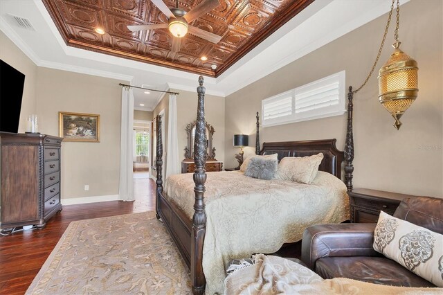 bedroom featuring coffered ceiling, a raised ceiling, dark hardwood / wood-style floors, ceiling fan, and ornamental molding