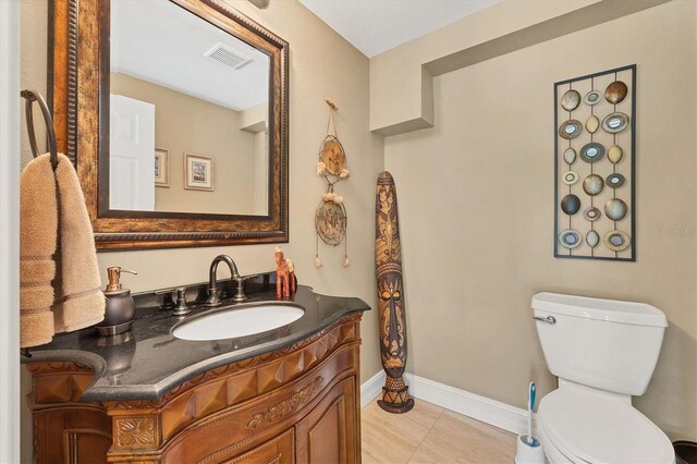 bathroom with tile patterned flooring, vanity, and toilet