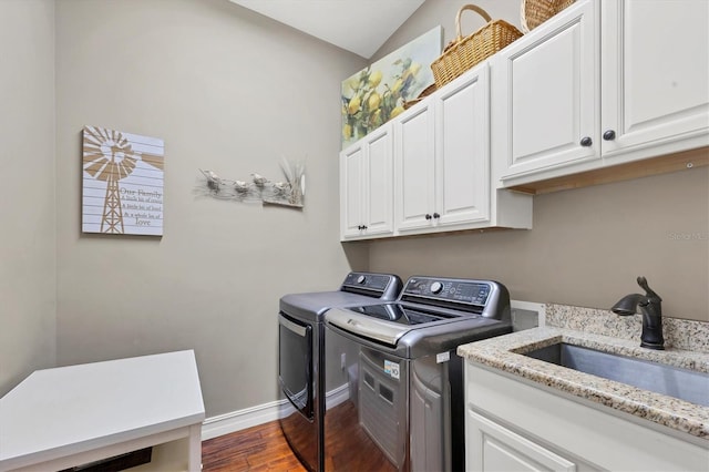 laundry area with washing machine and dryer, dark wood-type flooring, cabinets, and sink